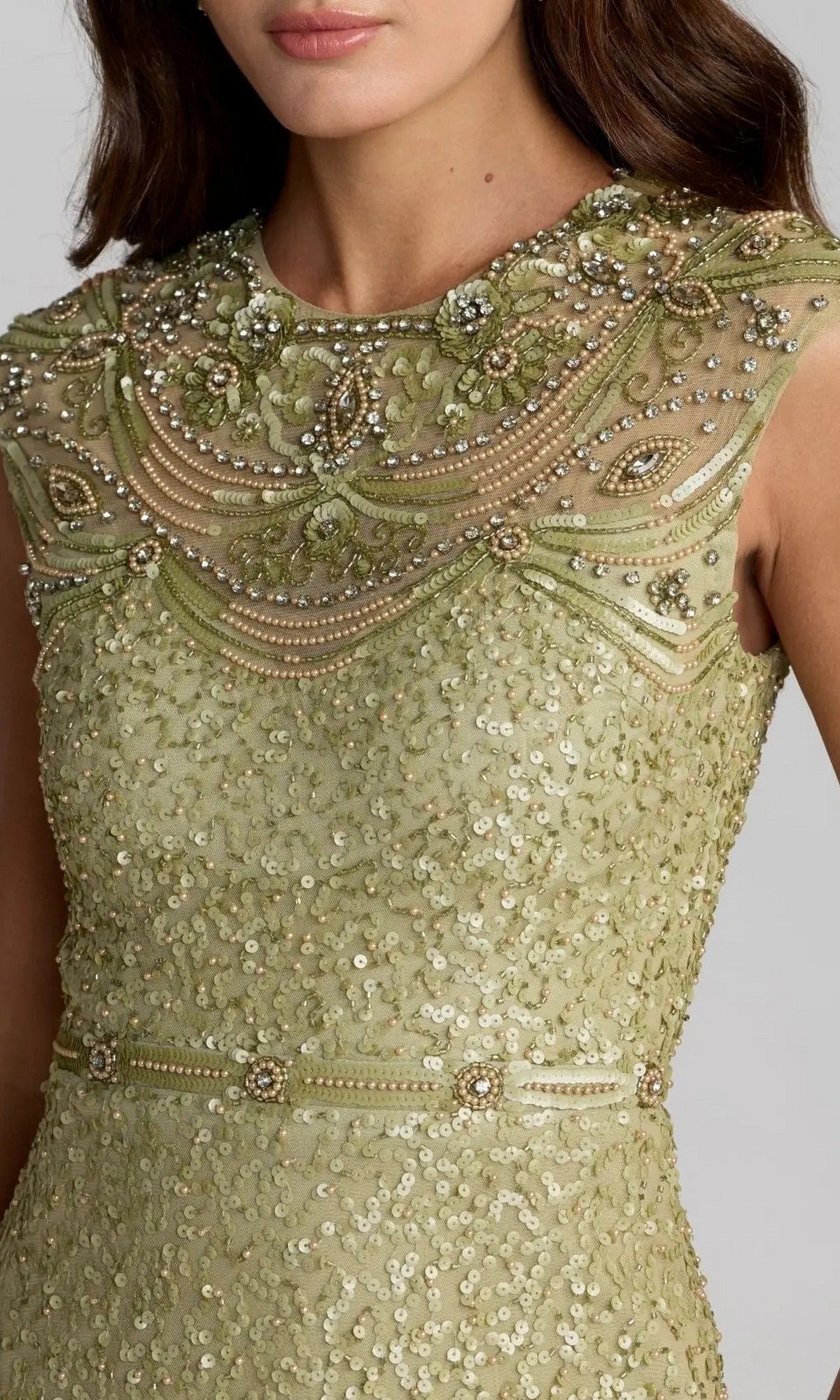 A woman wearing the Mac Duggal 23095 Long Formal Dress, a sleeveless light green sequin gown embellished with beads and floral embroidery on the bodice and featuring a beaded neckline—perfect for formal evening occasions.